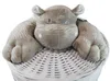 A plush hippo toy sits on top of a white wicker laundry basket. Produktbild-Vorschau