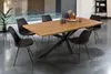 A dining table with chairs in a modern room with large windows. Produktbild-Vorschau