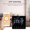 A hand holding a smartphone displaying a thermostat app next to a digital thermostat on a table. Podgląd zdjęcia produktu