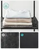 A stack of folded clothes on a shelf, with two close-up fabric texture comparisons below. Produktbild-Vorschau