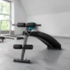 A black sit-up bench is shown in a gym or fitness room. Náhľad obrázku produktu