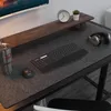A desk setup with a monitor, keyboard, mouse, headphones, and a desk mat. Produktbild-Vorschau