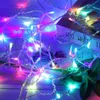 A close-up of colorful LED string lights tangled together, with a book in the background. Produktbild-Vorschau