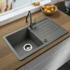 A grey kitchen sink with a chrome faucet is shown on a wooden countertop. Produktbild-Vorschau