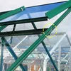 Close-up view of greenhouse roof structure with green metal framing and blue glass panels. A small metal clip is highlighted with a yellow dashed circle. Náhled obrázku produktu