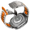 The back of a smartwatch with a metal and orange watchband is shown. Náhled obrázku produktu