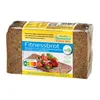 A loaf of Mestemacher Fitnessbrot on a white background, with a slice of bread topped with salad in the foreground. Produktbild-Vorschau