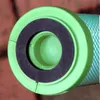 A close-up view of the end of a green cylindrical object with a black ring. Náhľad obrázku produktu