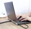 A person's hands are typing on a laptop that is connected to a docking station. Produktbild-Vorschau