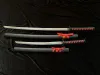 Two katanas and two wakizashis are displayed on a black fabric background. The swords are partially sheathed, with red ribbons tied around the sheaths. Voir les images du produit