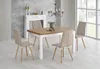 A dining table and chairs set in a well-lit room with a fireplace and large windows. Produktbild-Vorschau