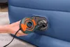 A hand is holding an electric pump and attaching it to an air mattress. Produktbild-Vorschau