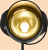 A close-up, front-facing view of a black outdoor spotlight with a warm white LED light. Produktbild-Vorschau