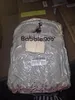 A product bag with a backpack inside, placed on top of cardboard boxes. Náhled obrázku produktu