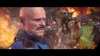 A close-up of a bald man with a mustache wearing chainmail and armor, with a blurred background of a battle scene with fire and soldiers. Produktbild-Vorschau