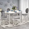 A dining room scene with a white table and chairs set on a floral rug. Náhľad obrázku produktu