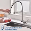 A person is using a kitchen faucet to rinse tomatoes in a bowl, with pasta in the background. Podgląd zdjęcia produktu