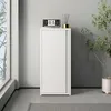 A white metal cabinet with a sliding door is shown in a room with a large window and a plant. Voir les images du produit