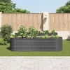 Two raised garden beds filled with plants are shown in a backyard setting, with a wooden fence and paved patio in the background. Produktbild-Vorschau