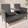 A modern gray rattan garden bench with a built-in table and black cushions, placed on a wooden deck with a patterned rug. Produktbild-Vorschau
