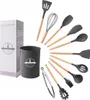 A set of silicone kitchen utensils with wooden handles, displayed fanned out around a utensil holder and a box. Náhľad obrázku produktu