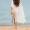 A woman walks on a beach holding a water bottle. Náhľad obrázku produktu
