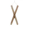 A pair of wooden skis, tied together with twine, hanging against a white background. Produktbild-Vorschau