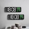 Two digital clocks are mounted on a light gray wall, displaying the time and temperature/humidity. Voir les images du produit