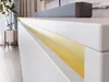 A close-up view of a white TV stand with a gold accent. Náhled obrázku produktu