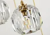 Close-up of a crystal pendant light fixture with a gold-colored metal accent and visible LED light bulbs. Podgląd zdjęcia produktu