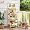 A wooden plant stand with various potted plants on a porch. Anteprima dell’immagine prodotto