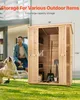 A man and his dog are in a backyard next to a wooden storage shed. Produktbild-Vorschau