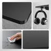 Collage of images showing details of a black desk, headphones on a hook, and a hand cleaning the desk surface. Anteprima dell’immagine prodotto