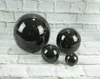 Four black decorative spheres of varying sizes are arranged on a white brick-like surface. Anteprima dell’immagine prodotto