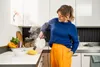 A woman is cleaning a kitchen counter with a steam cleaner. Voir les images du produit