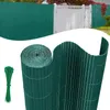 A roll of green PVC privacy screen material and a bundle of green zip ties are shown against a white background, with a blurred background image of a green fence and gate. Náhled obrázku produktu