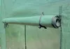 A rolled-up green mat is attached to the side of a green greenhouse. Náhled obrázku produktu