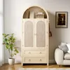 A light wood cabinet with rattan doors and drawers, styled in a room with a plant and a sofa. Podgląd zdjęcia produktu