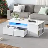 A modern white coffee table with LED lighting and drawers is placed in a living room setting next to a sofa and a Christmas tree. Náhled obrázku produktu