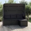 A black rattan garden sofa with a canopy and ottoman sits on a wooden deck, surrounded by greenery. Podgląd zdjęcia produktu