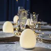 A table setting with decorative egg-shaped lamps and fairy lights. Produktbild-Vorschau