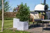 An outdoor patio scene with planters, a chair, and a pizza oven. Produktbild-Vorschau