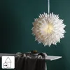 A white paper star lantern hangs in front of a dark green wall, with a small potted plant on a table below. Podgląd zdjęcia produktu