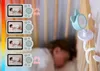 A baby monitor camera attached to a crib, with multiple screens showing a baby sleeping. Náhľad obrázku produktu