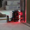 A laser level tool is being used on a construction site, projecting red laser lines. Produktbild-Vorschau