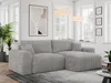 A modern living room with a gray cord sofa, plants, and artwork.