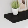 A black floating shelf with a potted plant and a framed picture on it, against a white wall. Náhled obrázku produktu