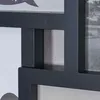 A close-up view of a black multi-photo frame, showing the frame structure and a concrete wall in the background. Produktbild-Vorschau