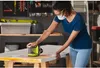 A woman is using a sander on a table in a workshop. Podgląd zdjęcia produktu