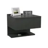 A dark gray modern nightstand with a drawer and a shelf, featuring a framed picture and a digital clock on top, and a smartphone on the shelf. Náhled obrázku produktu